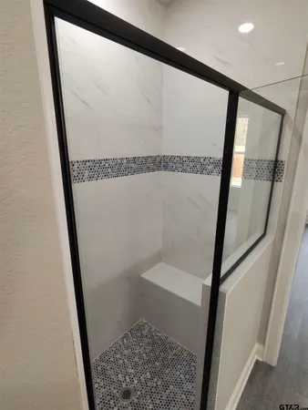 a bathroom with a shower and a mirror
