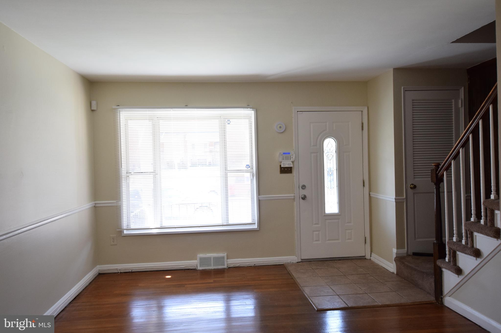 565 Brisbane Road Baltimore, MD 21229 - Photo 2 of 11 an empty room with wooden floor and windows