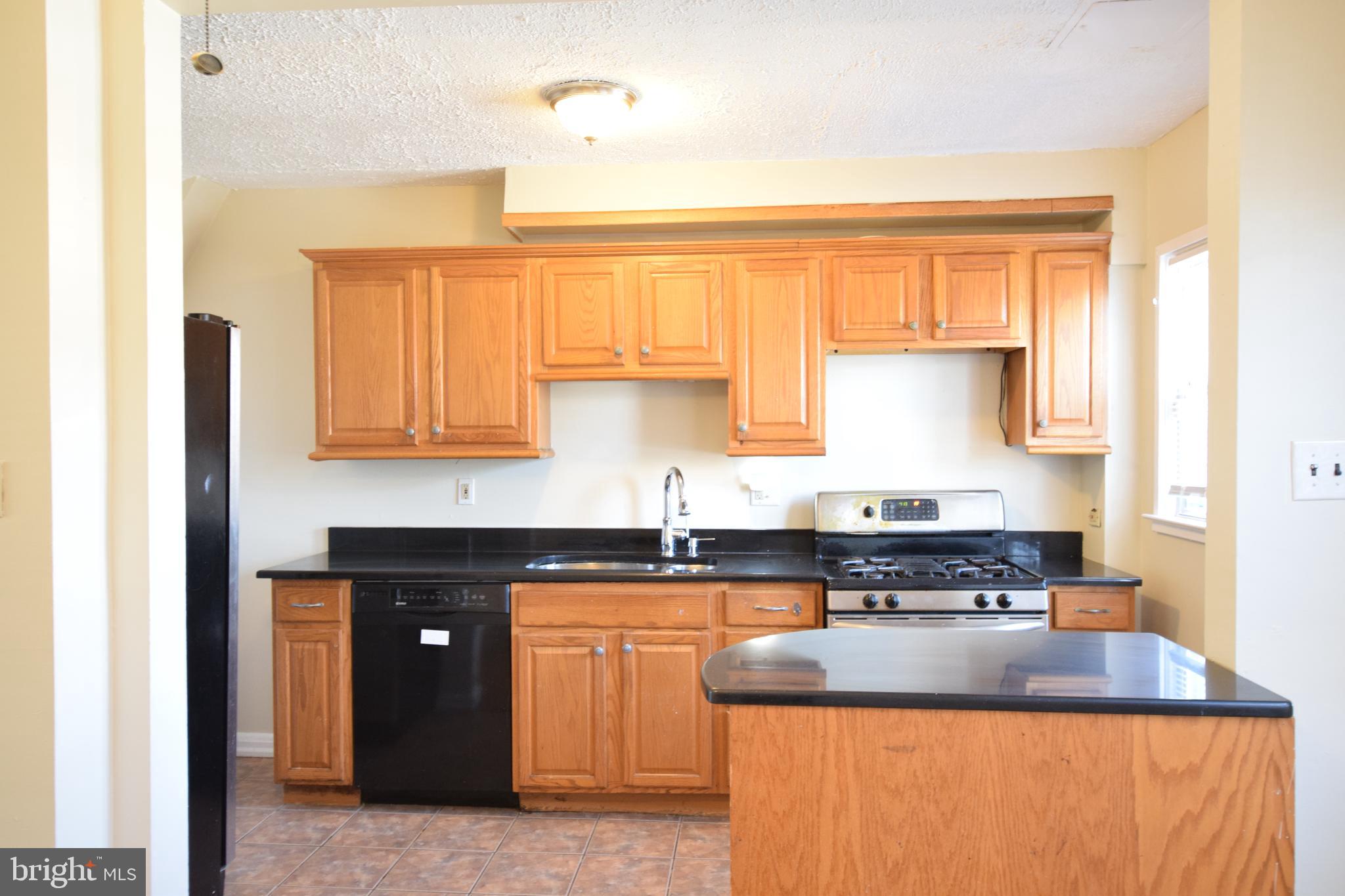 565 Brisbane Road Baltimore, MD 21229 - Photo 4 of 11 a kitchen with granite countertop a sink a stove and cabinets