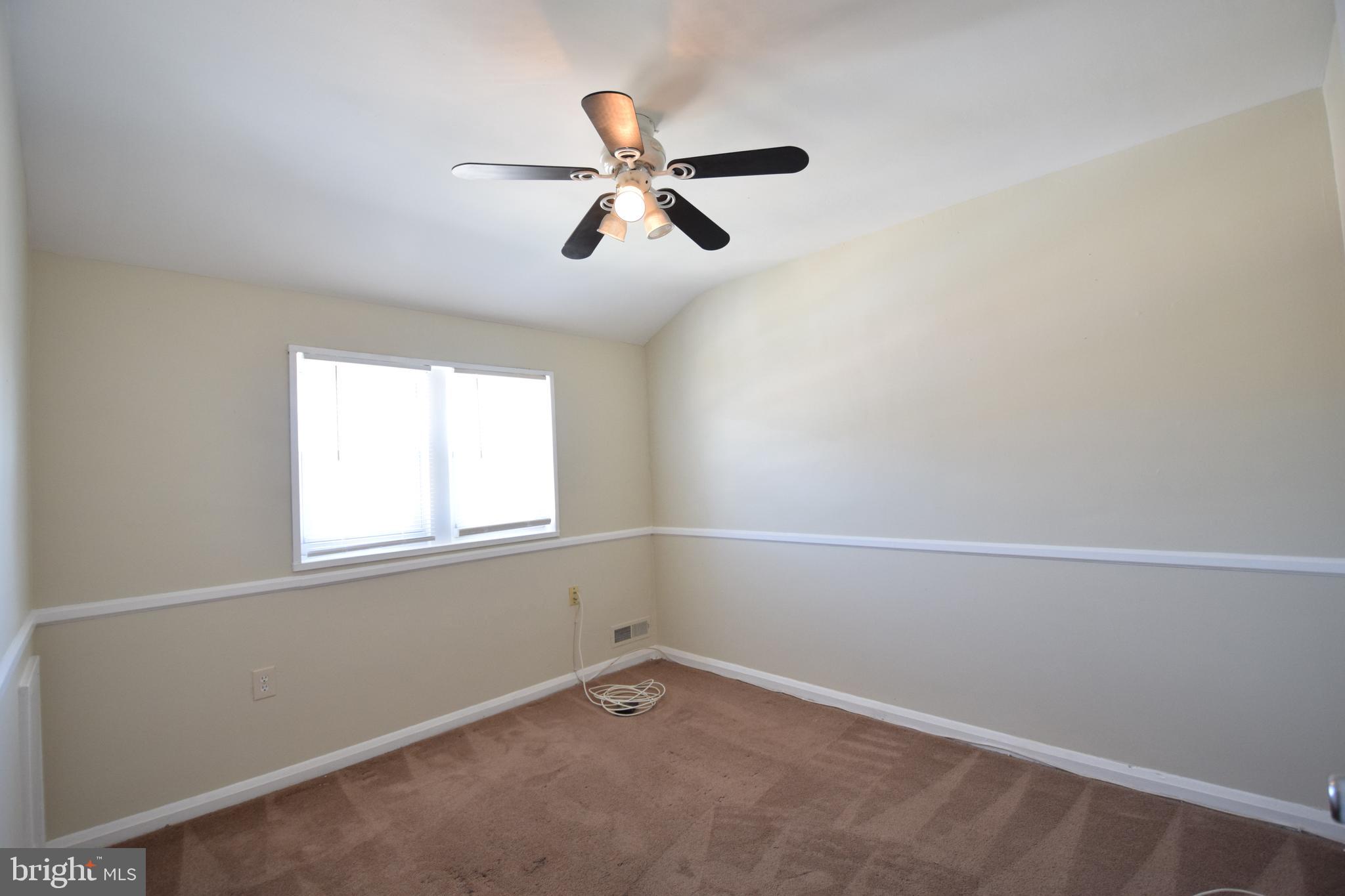 565 Brisbane Road Baltimore, MD 21229 - Photo 7 of 11 an empty room with a window and a fan