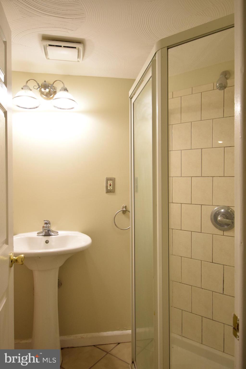 565 Brisbane Road Baltimore, MD 21229 - Photo 9 of 11 a bathroom with a sink shower and a mirror