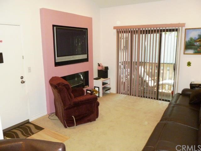 Upgraded & Nice size living room with newer plush carpet & wood floor entry, with Fireplace & built in entertainment center with speakers