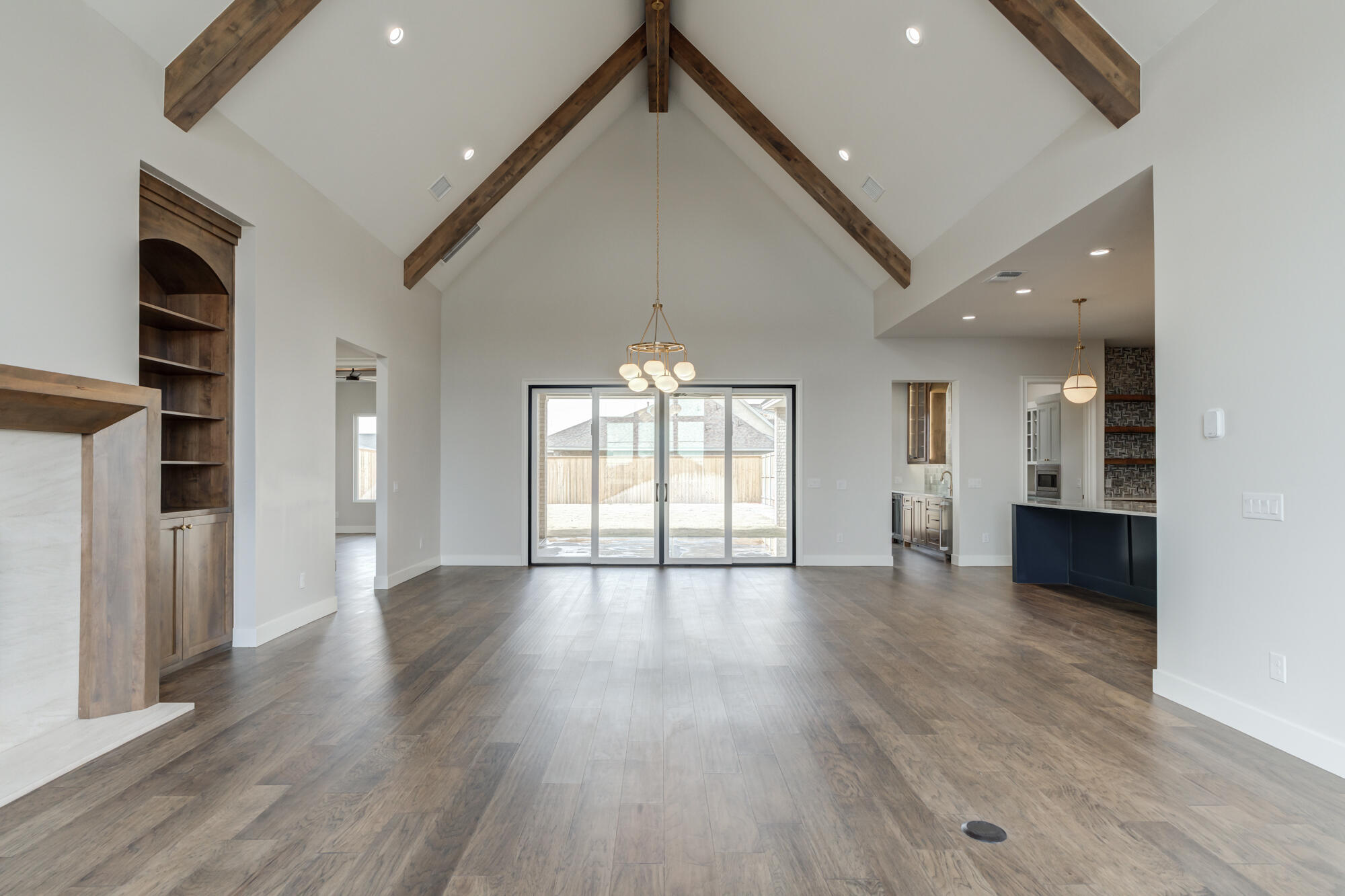 14102 Salisbury Avenue Lubbock, TX 79424 - Photo 13 of 76 wooden floor in an empty room with a kitchen and a window