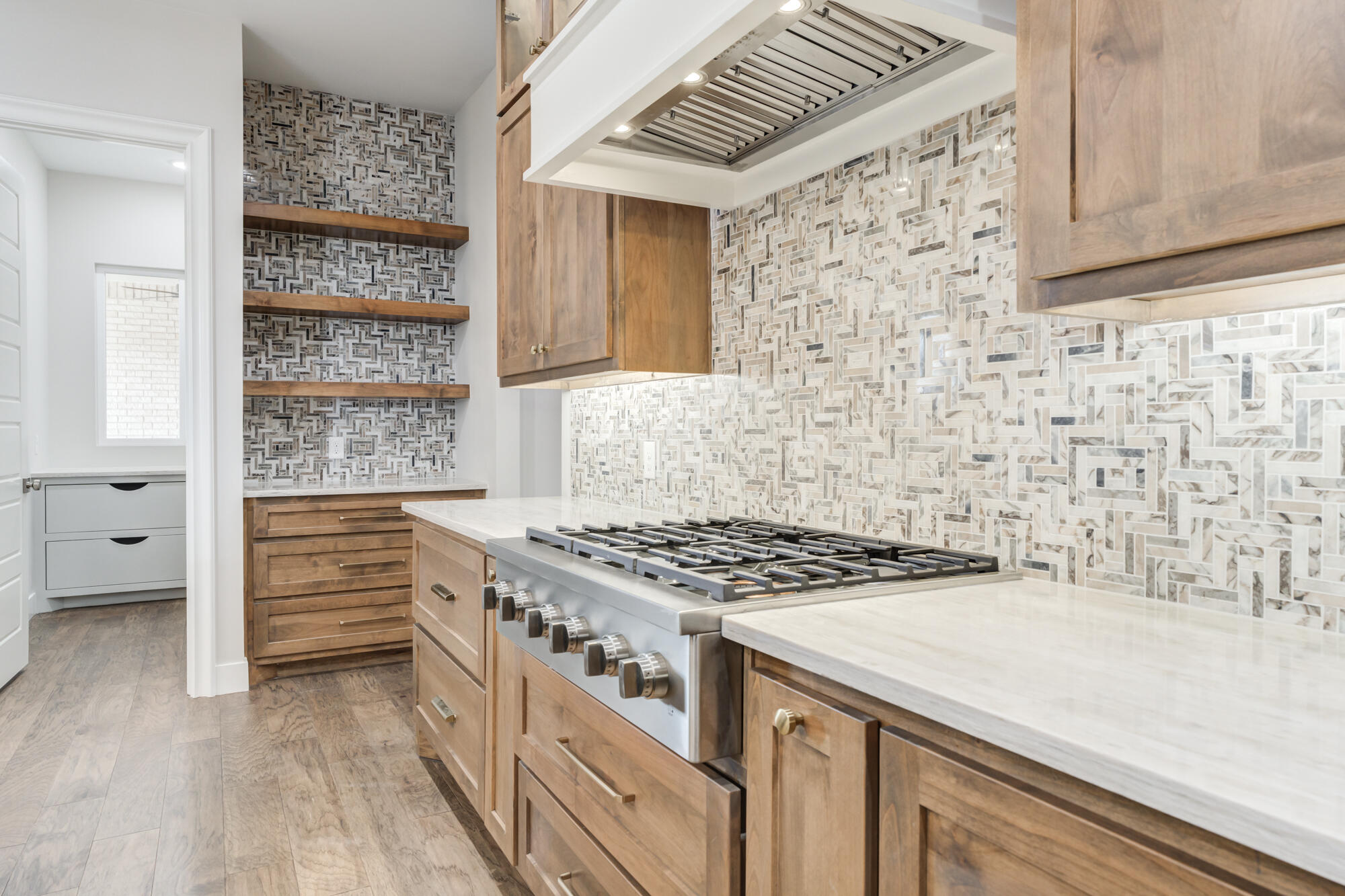 14102 Salisbury Avenue Lubbock, TX 79424 - Photo 23 of 76 a kitchen with granite countertop a stove and a wooden cabinets