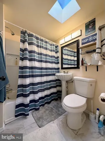 a bathroom with a sink a toilet and a shower