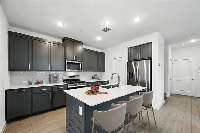 a kitchen with a sink cabinets and wooden floor