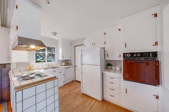 1024 West Riverside Way San Jose, CA 95129 - Photo 6 of 31 a kitchen with white cabinets and white appliances