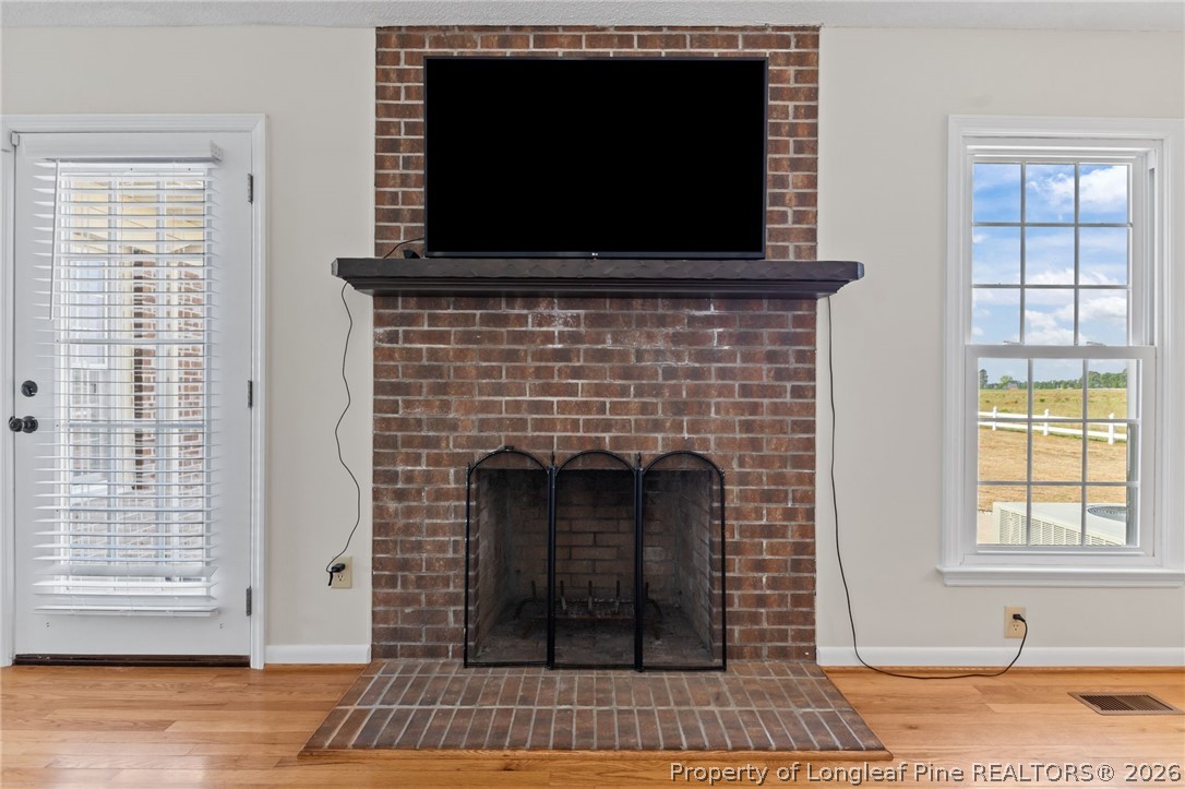 203 White Oak Church Road Clinton, NC 28328 - Photo 11 of 49 a living room with a fireplace a flat screen tv and a window