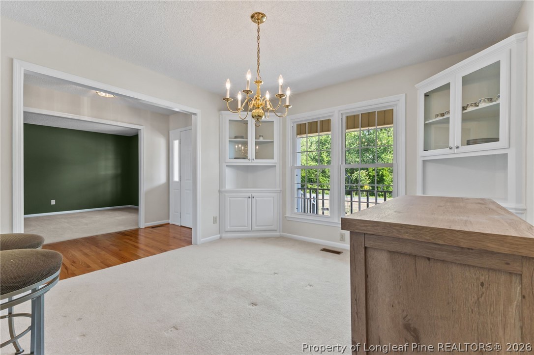 203 White Oak Church Road Clinton, NC 28328 - Photo 14 of 49 a bedroom with a bed and a chandelier