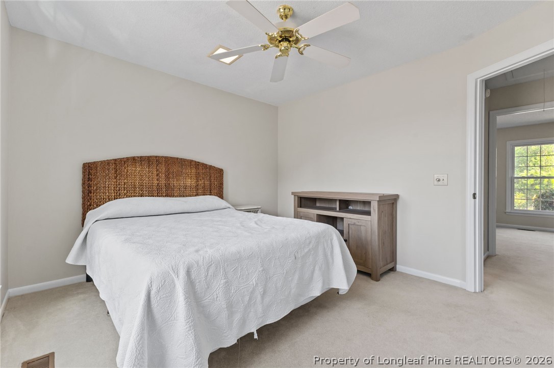 203 White Oak Church Road Clinton, NC 28328 - Photo 15 of 49 a bedroom with a bed and a chandelier