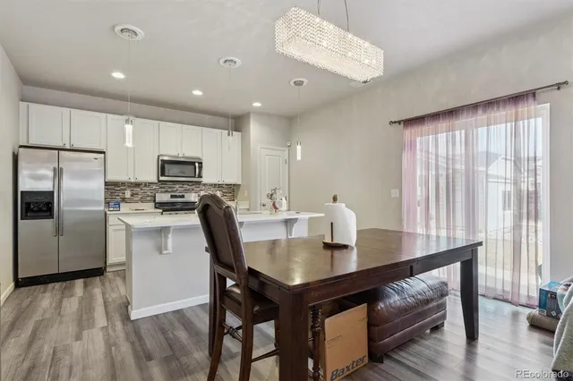 a kitchen with a refrigerator a stove a sink and dishwasher with wooden floor