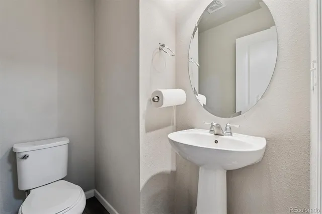 a bathroom with a sink toilet and a mirror