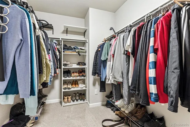 a view of walk in closet with clothes and shoes