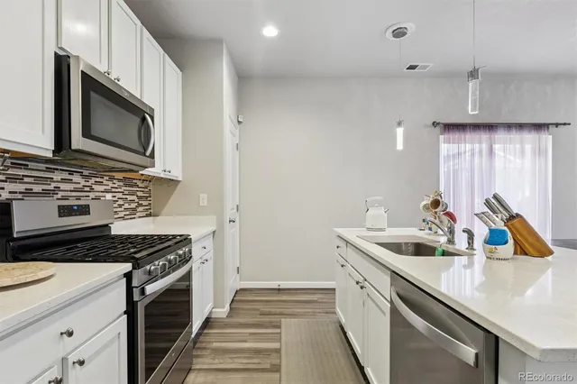a kitchen with a sink stove and microwave