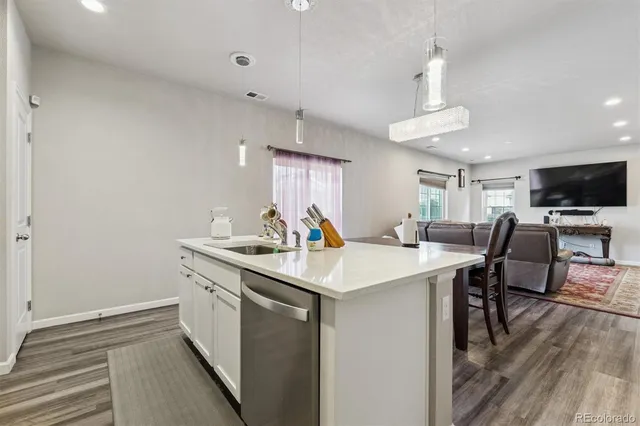 a kitchen with a sink cabinets and wooden floor