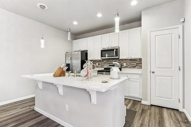a view of kitchen with microwave stove refrigerator and wooden cabinets