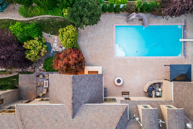 694 West Cephus Road Draper, UT 84020 - Photo 148 of 148 Expansive outdoor living area featuring a rectangular swimming pool with integrated slide and diving board, a stone fire pit, a covered patio area, and mature landscaping