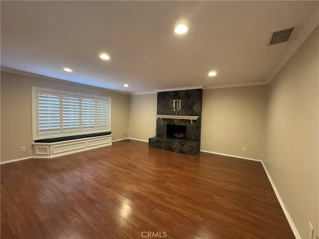a view of empty room with wooden floor and fireplace