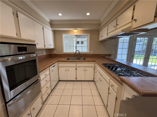 a kitchen with granite countertop a stove sink and cabinets