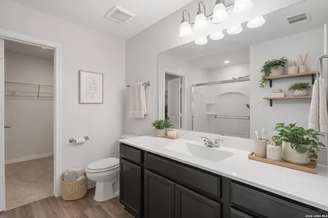 a bathroom with a sink a toilet and a large mirror
