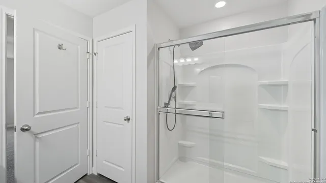 a bathroom with a sink a toilet a large mirror and shower