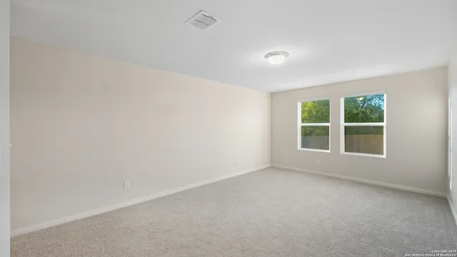 an empty room with a ceiling fan and window