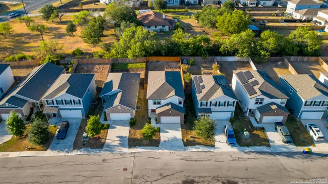 an aerial view of a residential apartment building with a yard and parking spaces