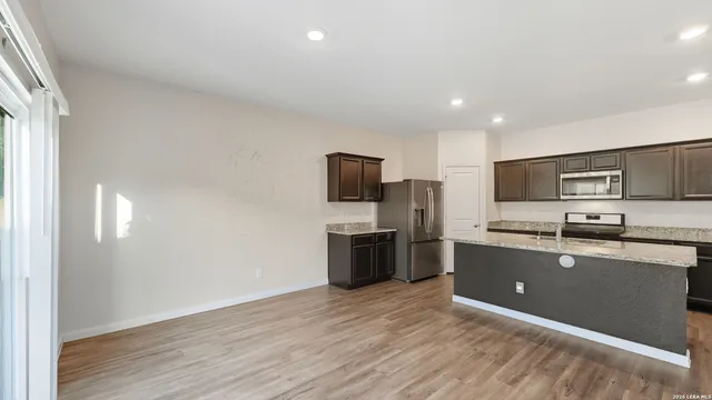 a large kitchen with stainless steel appliances granite countertop a stove a sink and a refrigerator