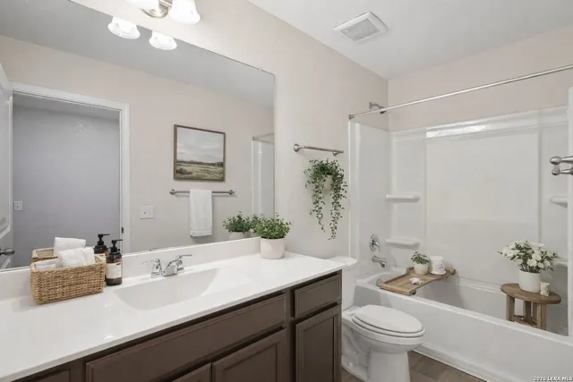a bathroom with a granite countertop sink mirror vanity and toilet