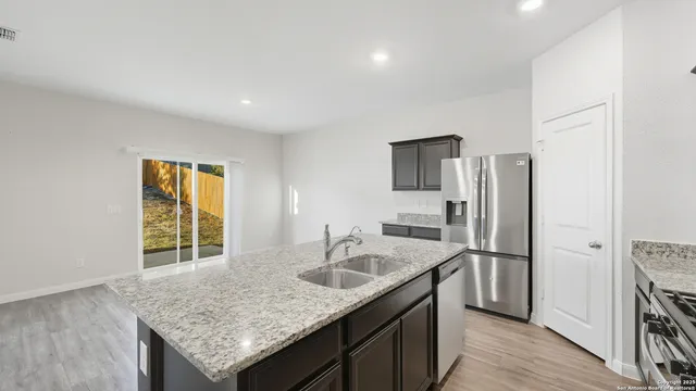 a kitchen with stainless steel appliances granite countertop a sink stove and refrigerator