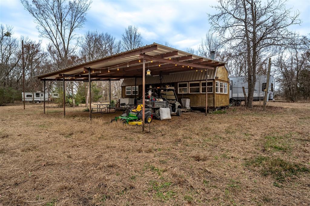 139 Northwest County Road, Unit 1061 Talco, TX 75487 - Photo 37 of 39 a view of a blue house with a yard and sitting area