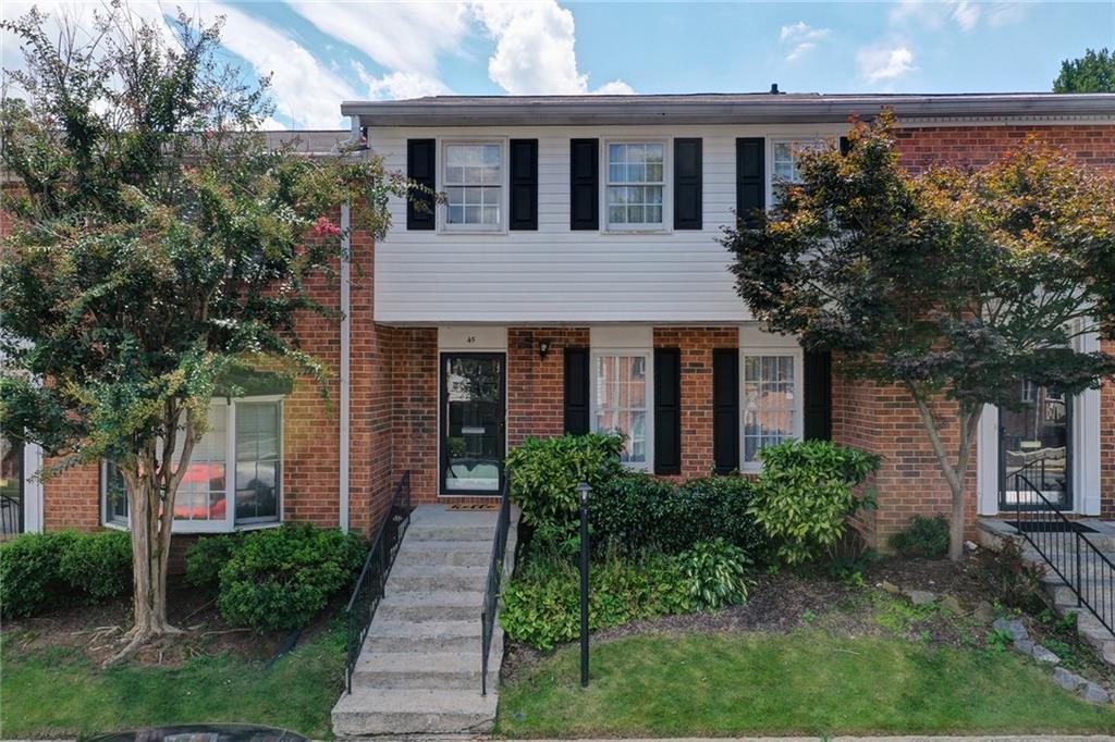 6520 Roswell Road Northeast, Unit 45 Atlanta, GA 30328 - Photo 1 of 1 a front view of a house with a yard and trees