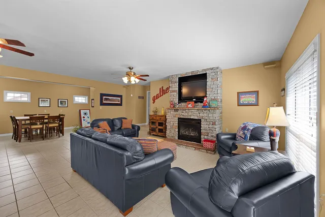a living room with furniture a fireplace and a large window