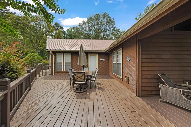 a view of a patio with table and chairs a barbeque with wooden floor and fence