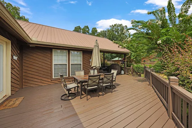 a view of a patio with table and chairs with wooden floor and fence