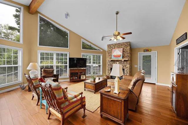 a living room with furniture a flat screen tv and a large window