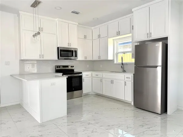 a kitchen with a refrigerator a stove a microwave and cabinets