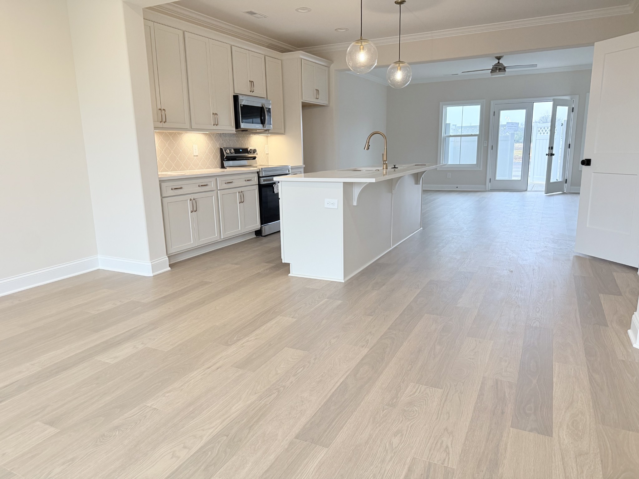 1341 Rebecca Johns Drive Murfreesboro, TN 37128 - Photo 11 of 32 a large kitchen with kitchen island a sink dishwasher stove and white cabinets with wooden floor