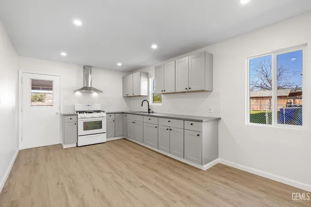 a kitchen with granite countertop white cabinets and white appliances