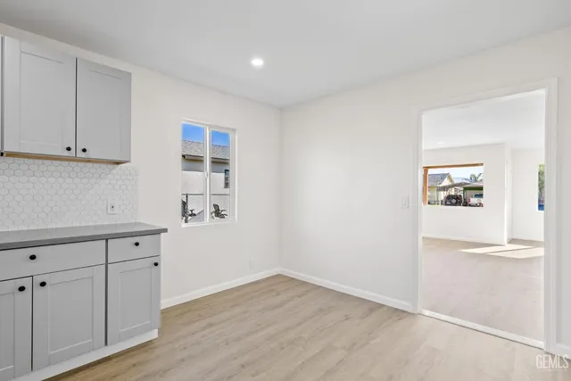 an empty room with wooden floor and cabinet