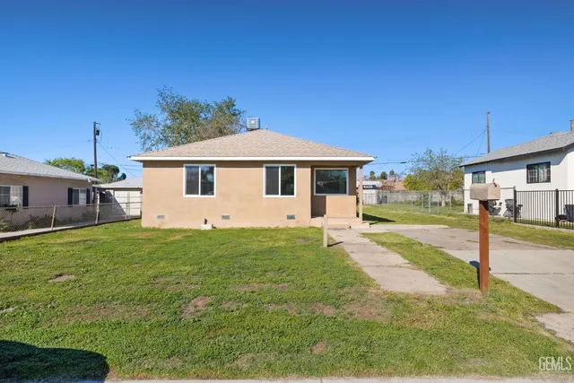 a view of a yard in front of a house with large tree