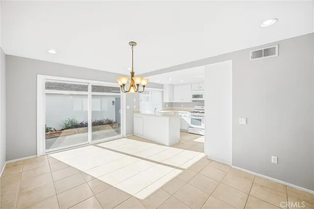 a open kitchen with white cabinets and refrigerator