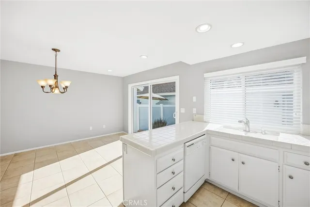 a kitchen with a refrigerator and white cabinets