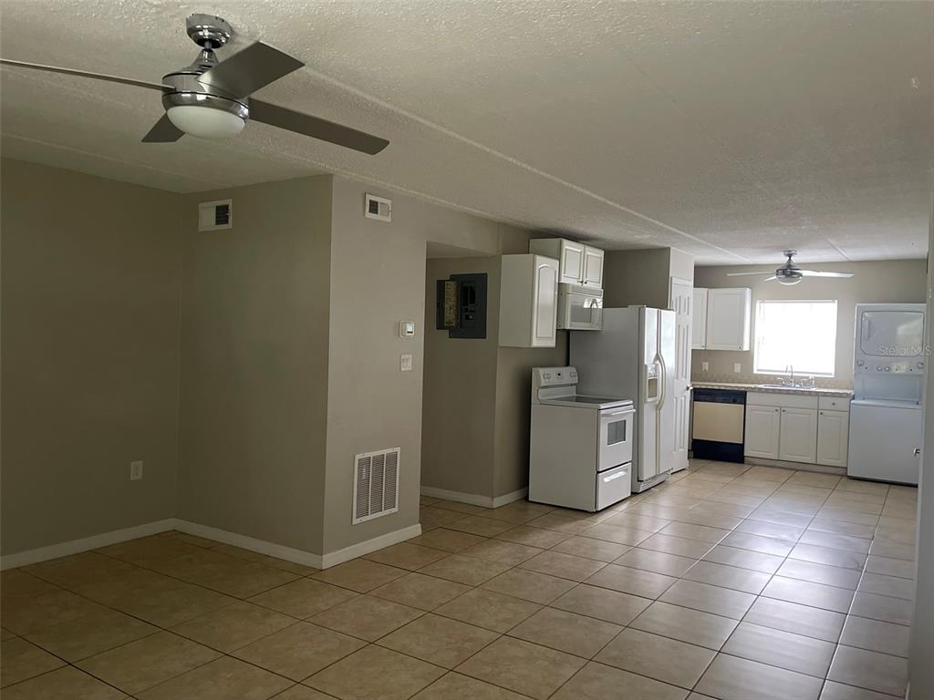 525 South Conway Road, Unit 109 Orlando, FL 32807 - Photo 5 of 18 a kitchen with a refrigerator and white cabinets