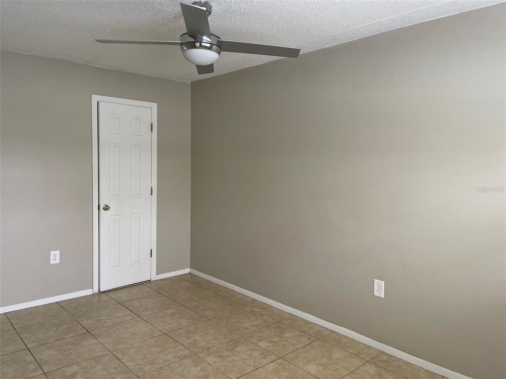 525 South Conway Road, Unit 109 Orlando, FL 32807 - Photo 9 of 18 an empty room with windows and fan