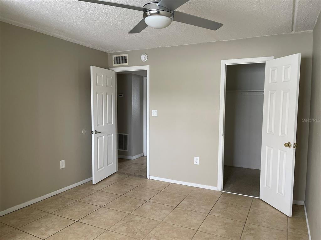 525 South Conway Road, Unit 109 Orlando, FL 32807 - Photo 10 of 18 an empty room with closet and a chandelier fan