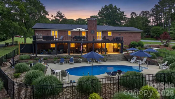 a front view of house and yard with swimming pool and outdoor seating