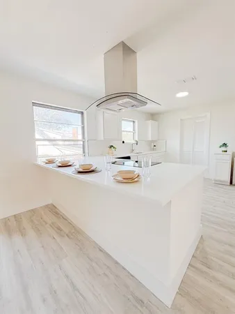 an empty room with windows and fireplace