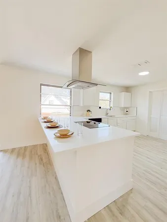 a kitchen with kitchen island white cabinets and appliances