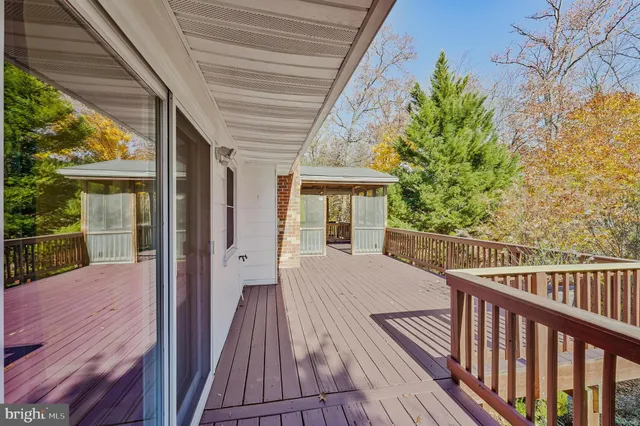 a balcony with wooden floor table and chairs